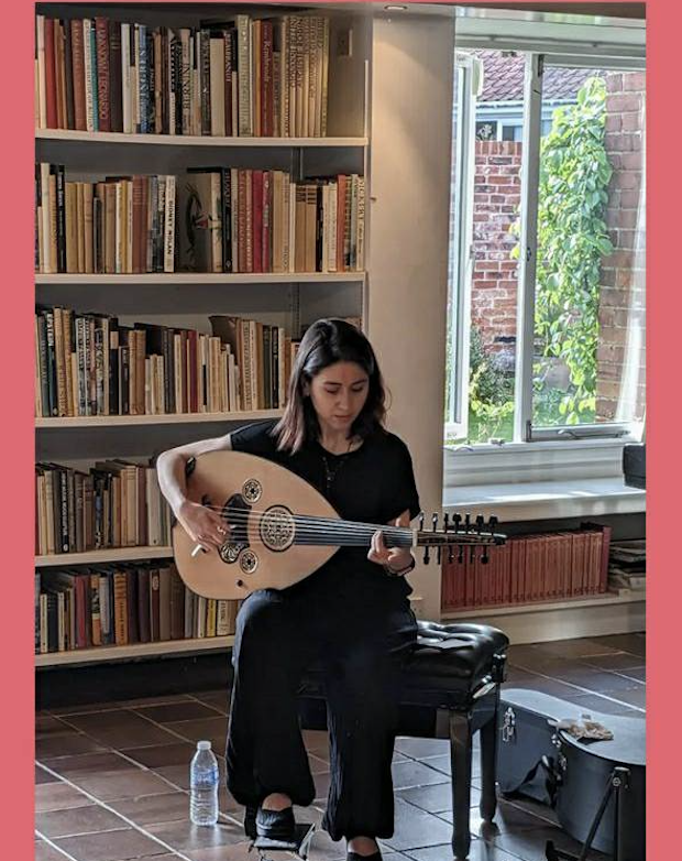 This is a photo of Rihab playing her instrument, the oud in a live concert in Suffolk, UK