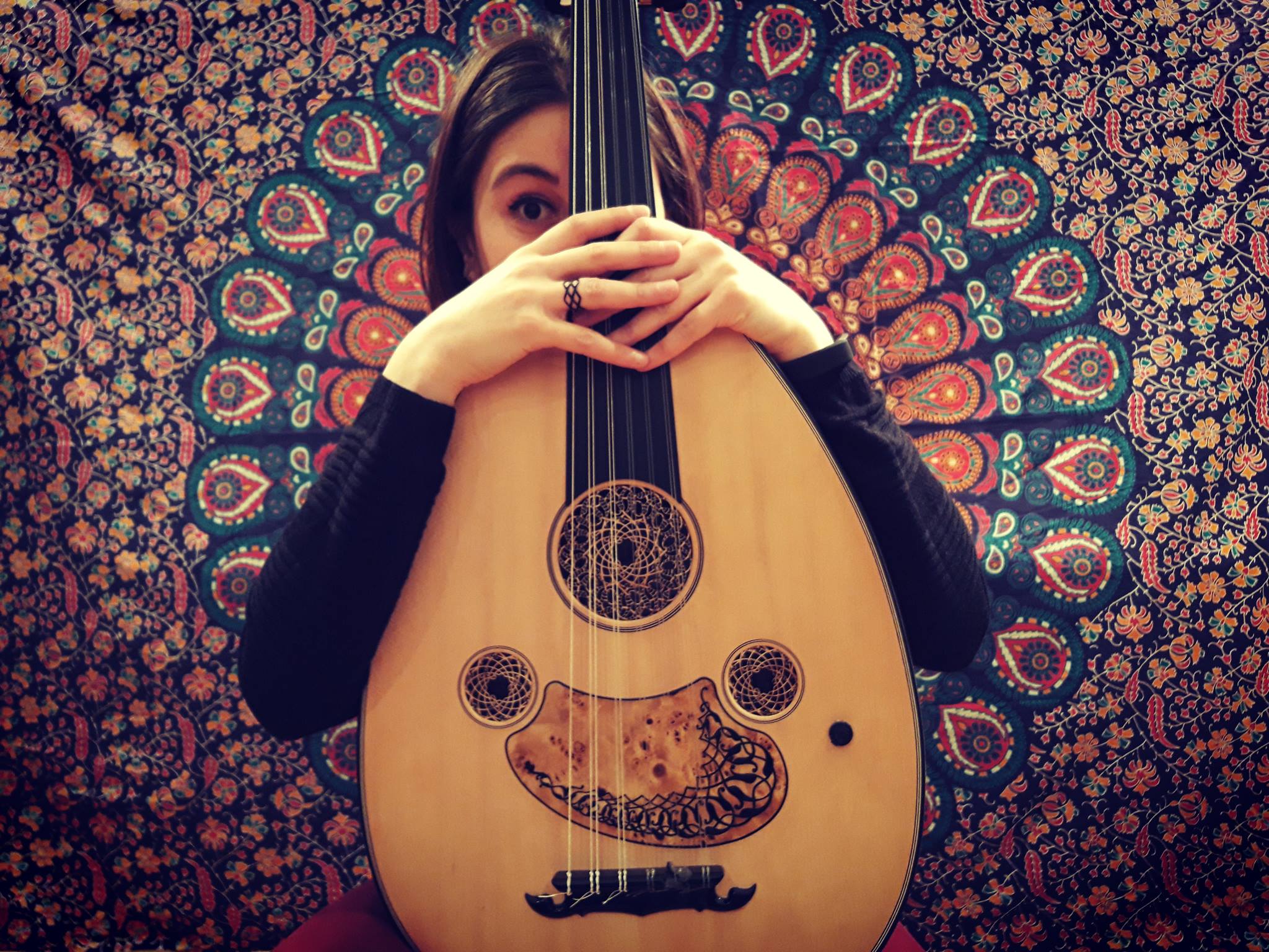 an image of Rihab holding her instrument, the oud
